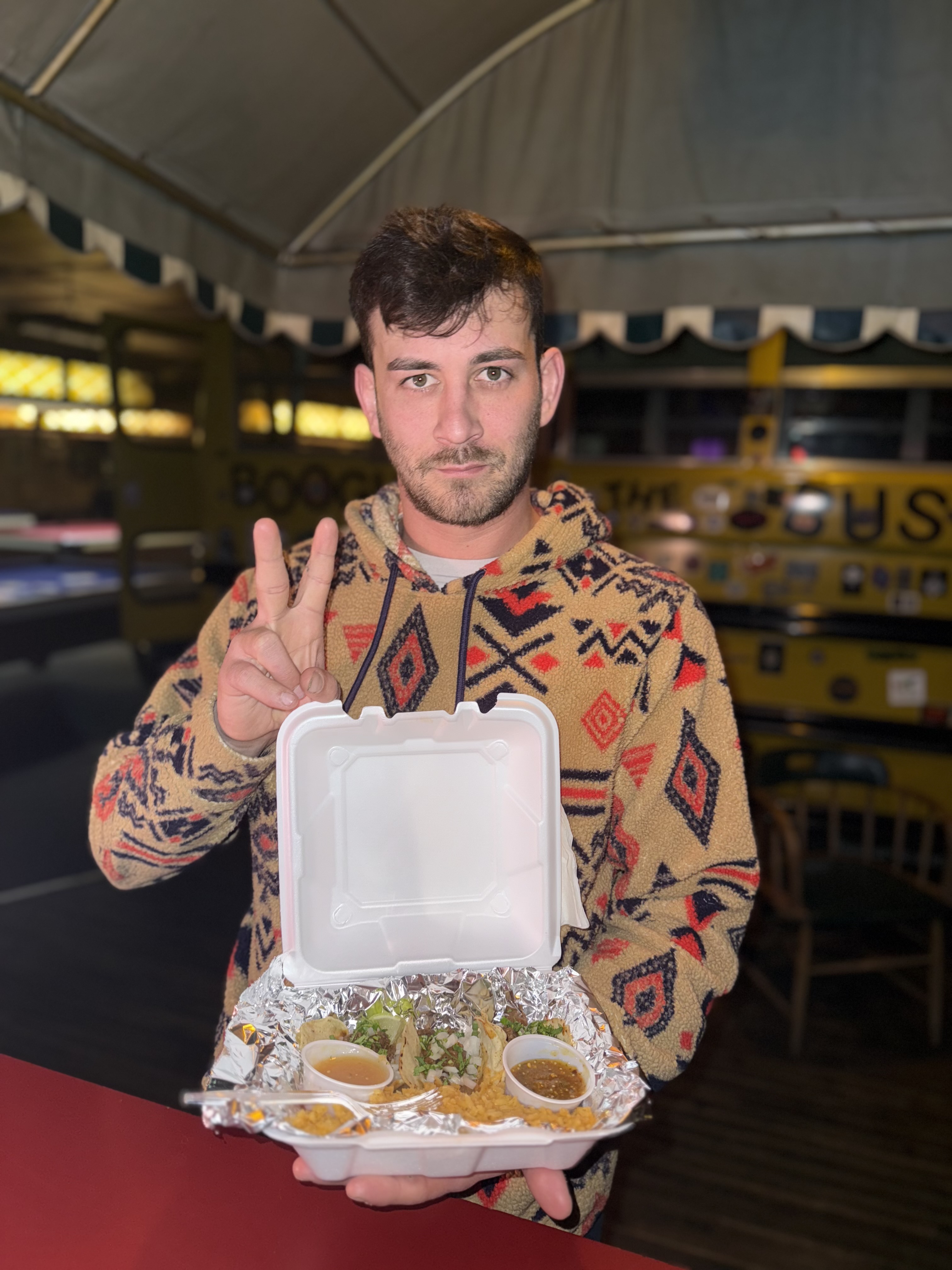 Customer holding a Tailored Tastes taco box at a pop-up event